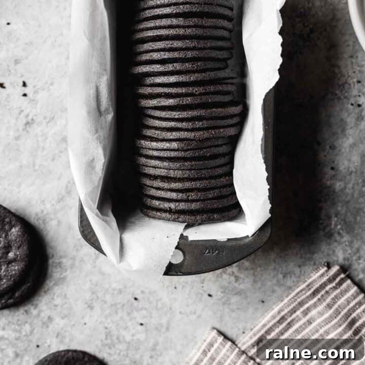 Chocolate Cookie Crust Recipe for Perfect Pie and Cheesecake 3 A row of round dark chocolate cookies in a parchment lined pan.