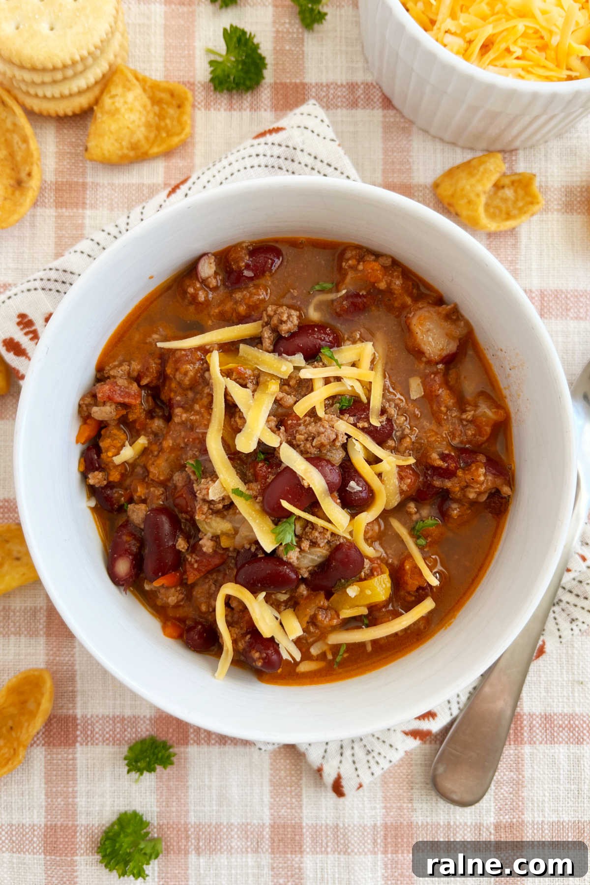 Classic Stove-Top Mom’s Chili Recipe for Weeknight Dinners 2 bowl of mild chili with ground beef and kidney beans and cheese cooked on stovetop