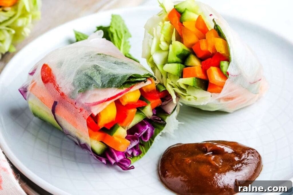 closeup of a summer roll on a white plate with homemade peanut sauce