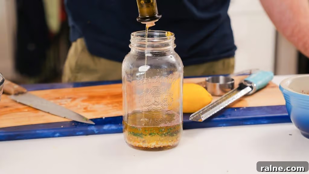 Lemon Thyme Vinaigrette Recipe — Bright Citrus Herb Dressing 3 Andy pouring the ingredients for Lemon Thyme Vinaigrette into an empty mason jar.