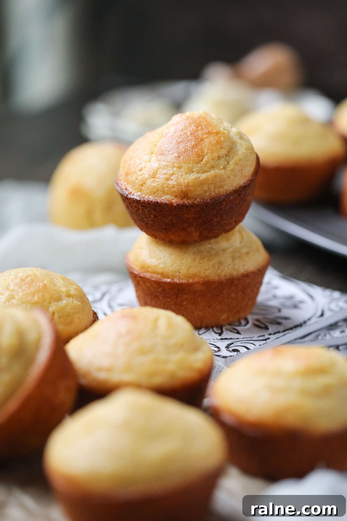 buttermilk cornbread muffins arranged on a wooden surface.