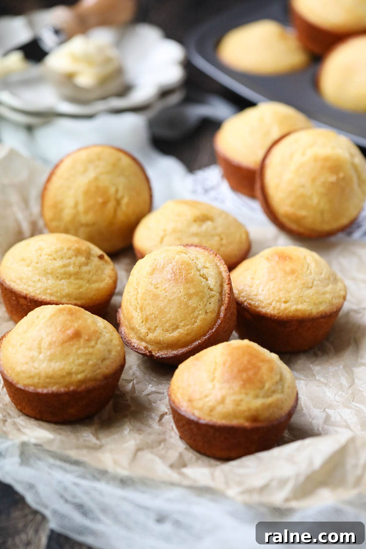 buttermilk cornbread muffins arranged on a wooden surface.