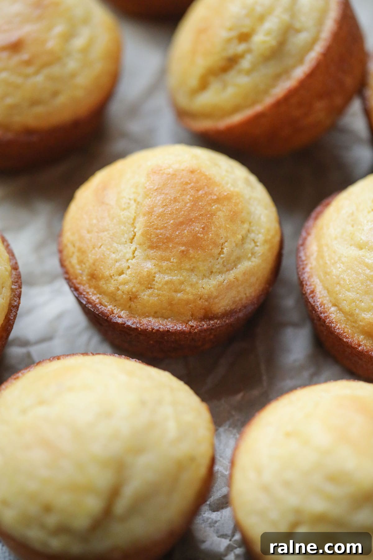 buttermilk cornbread muffins arranged on a wooden surface.