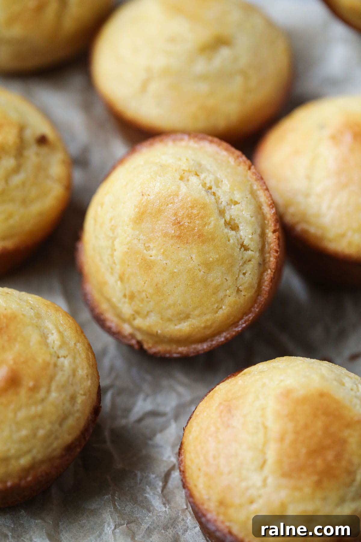 buttermilk cornbread muffins arranged on a wooden surface.