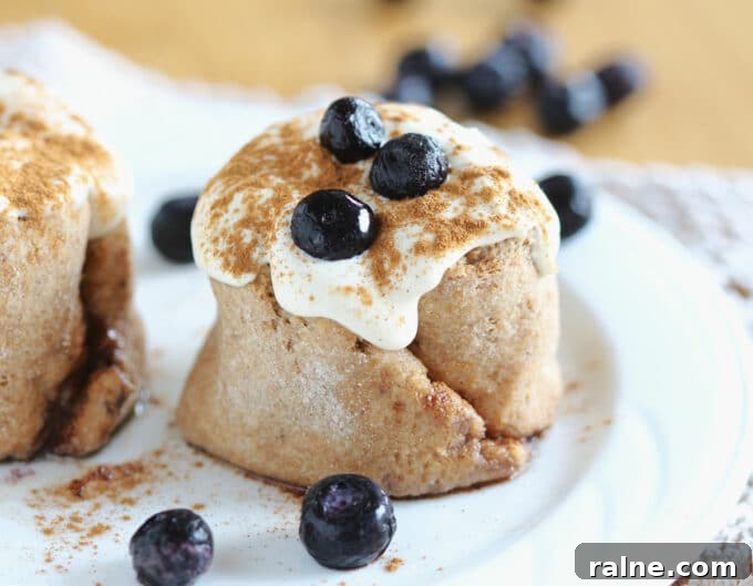 Single-Serve Blueberry Cinnamon Roll Recipe 2 Blueberry cinnamon roll on a white plate.
