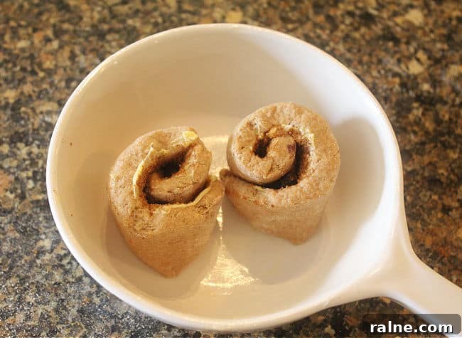 Single-Serve Blueberry Cinnamon Roll Recipe 11 Unbaked rolls in a white baking dish.
