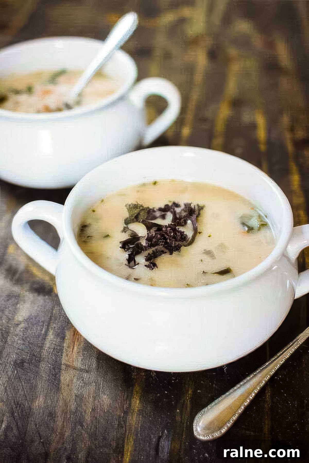 Creamy Cannellini Bean and Kale Soup Recipe for Cozy Nights 2 two white bowls of cannellini bean and kale soup on a rustic wood table