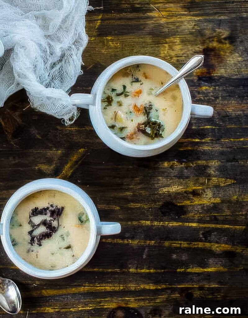 Creamy Cannellini Bean and Kale Soup Recipe for Cozy Nights 5 an overhead shot of two white bowls of cannellini bean and kale soup on a rustic wood table