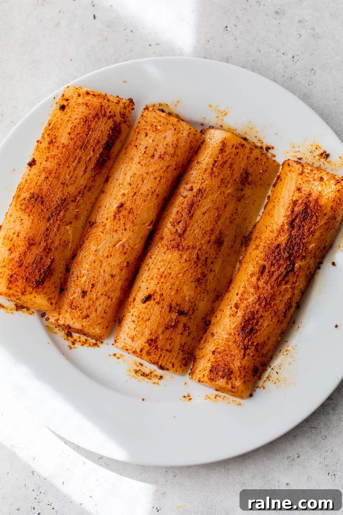 mahi mahi with seasonings on top on a plate