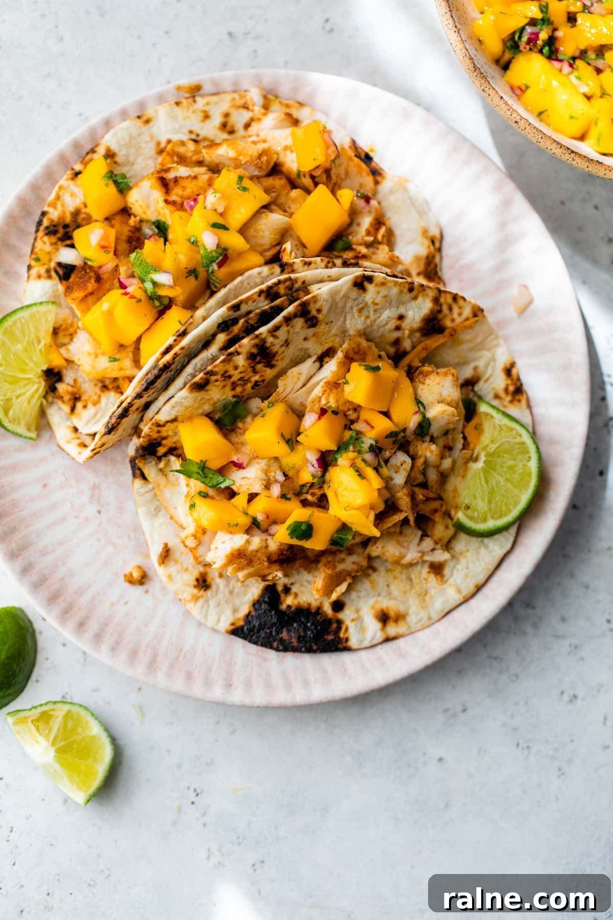 mahi mahi tacos on a plate with lime slices