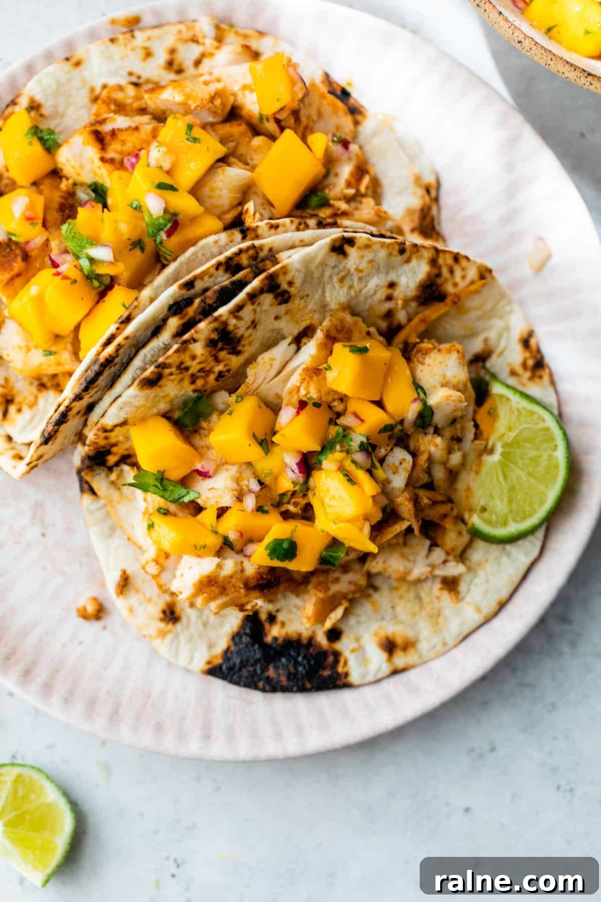 mahi mahi tacos on a plate with lime slices