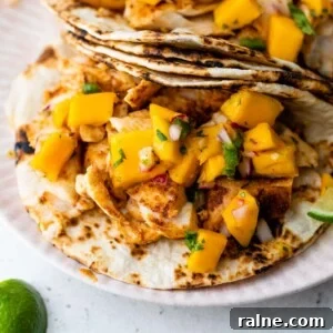 close-up of mahi mahi tacos on a plate with lime slices