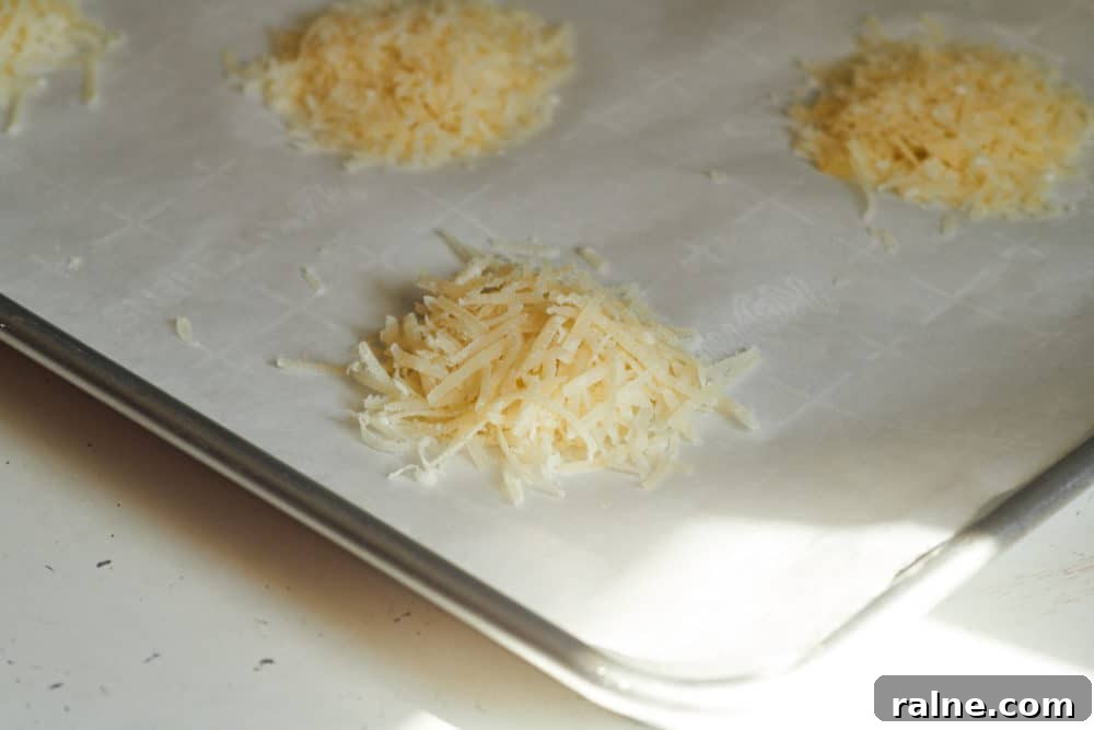 Salami Sandwich with Parmesan Crisps and Zesty Mostarda 4 Stacks of shredded parmigiano reggiano on parchment paper arranged on a baking sheet.