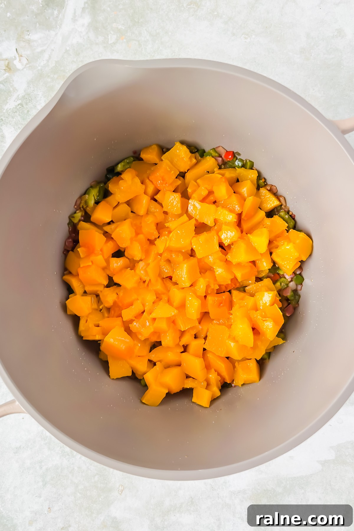 cooked butternut squash cubes over cooked and diced peppers and onions in large stock pot.