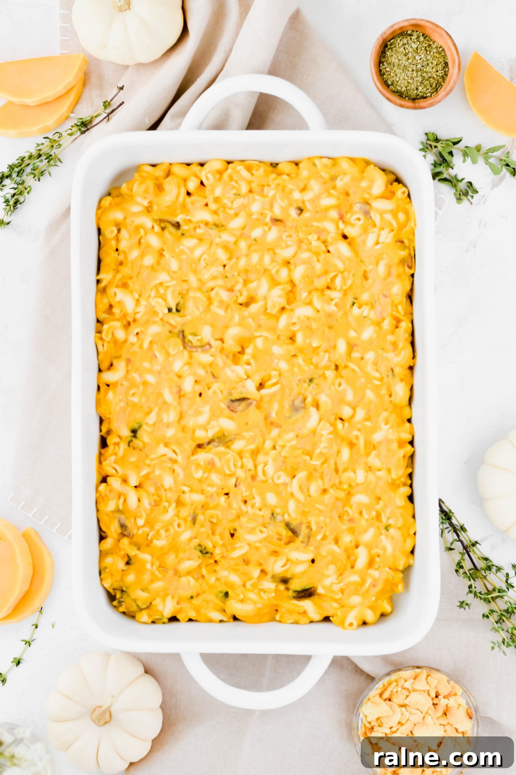 Large white dish filled with Butternut Squash Mac and Cheese with Trader Joe's Crackers crushed in bowl beside dish.