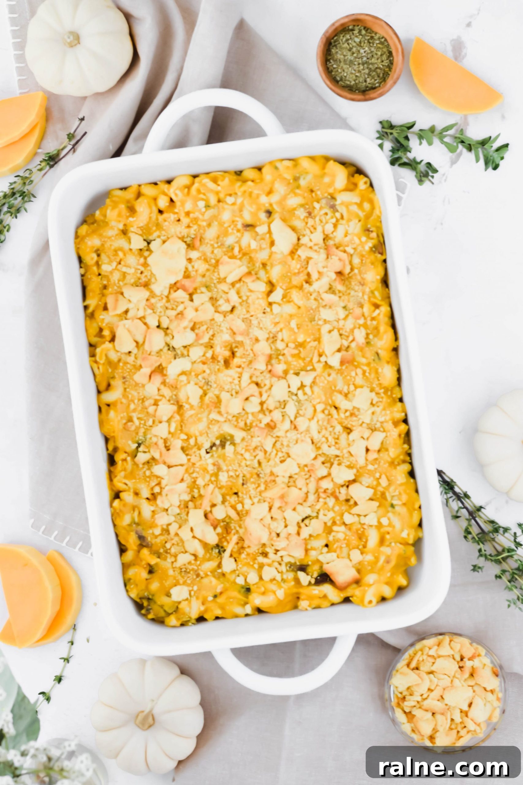 Large white dish filled with Butternut Squash Mac and Cheese with Trader Joe's Crackers on top.