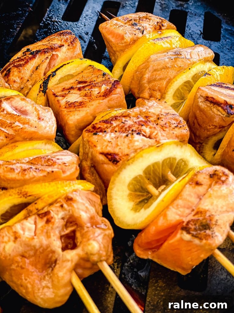 salmon kabobs being grilled over charcoal