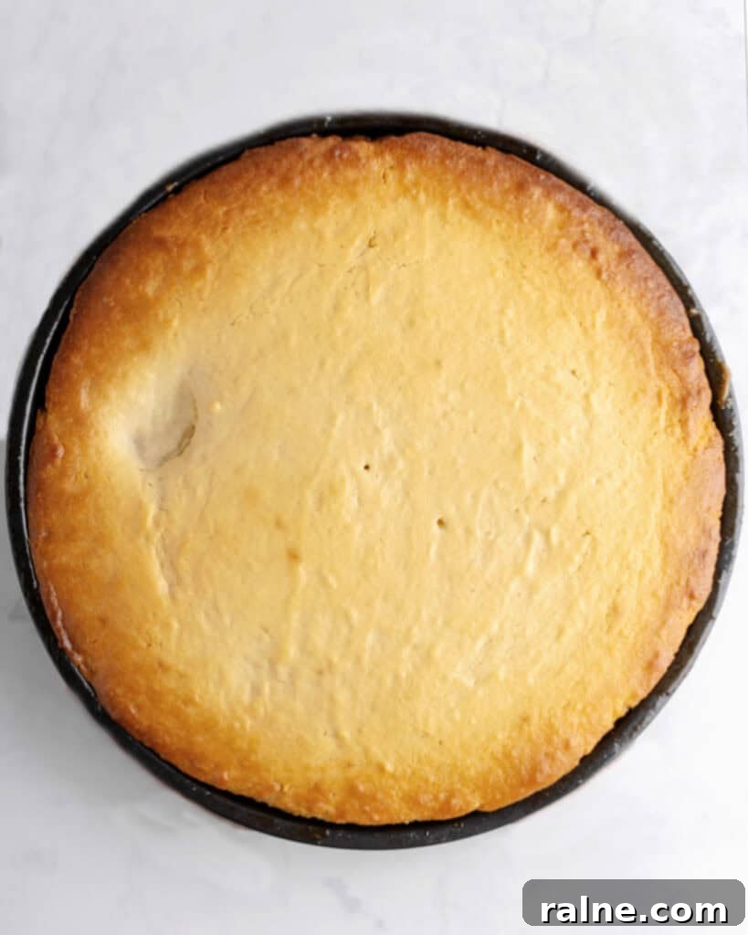 Baked upside down cake on a black round pan. Top view. Light gray surface.
