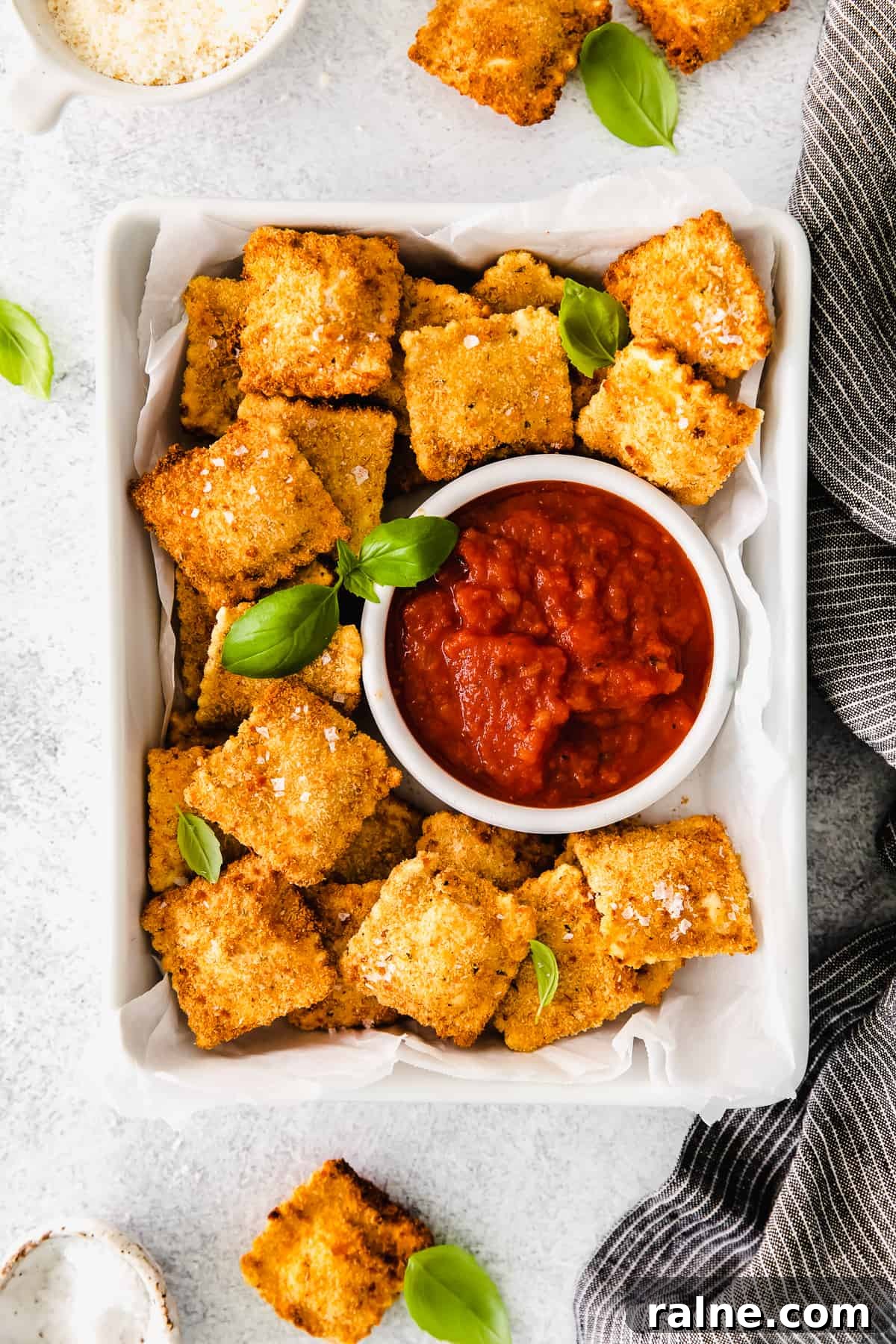 Crispy Air Fryer Ravioli Recipe — Quick Golden Bites 2 Air fryer ravioli served next to marinara sauce.