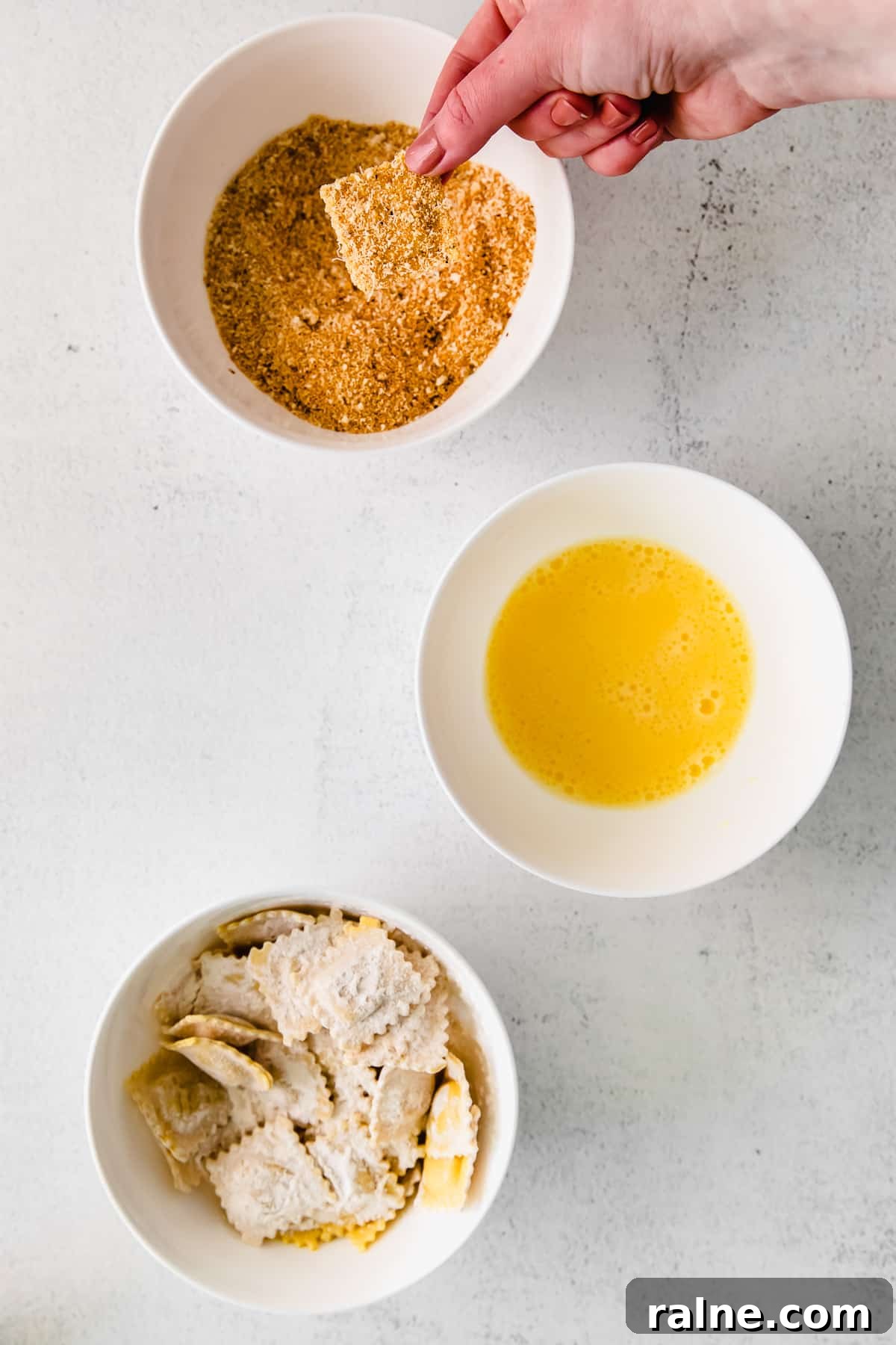 Crispy Air Fryer Ravioli Recipe — Quick Golden Bites 4 Dipping ravioli into a breadcrumb and parmesan mixture.