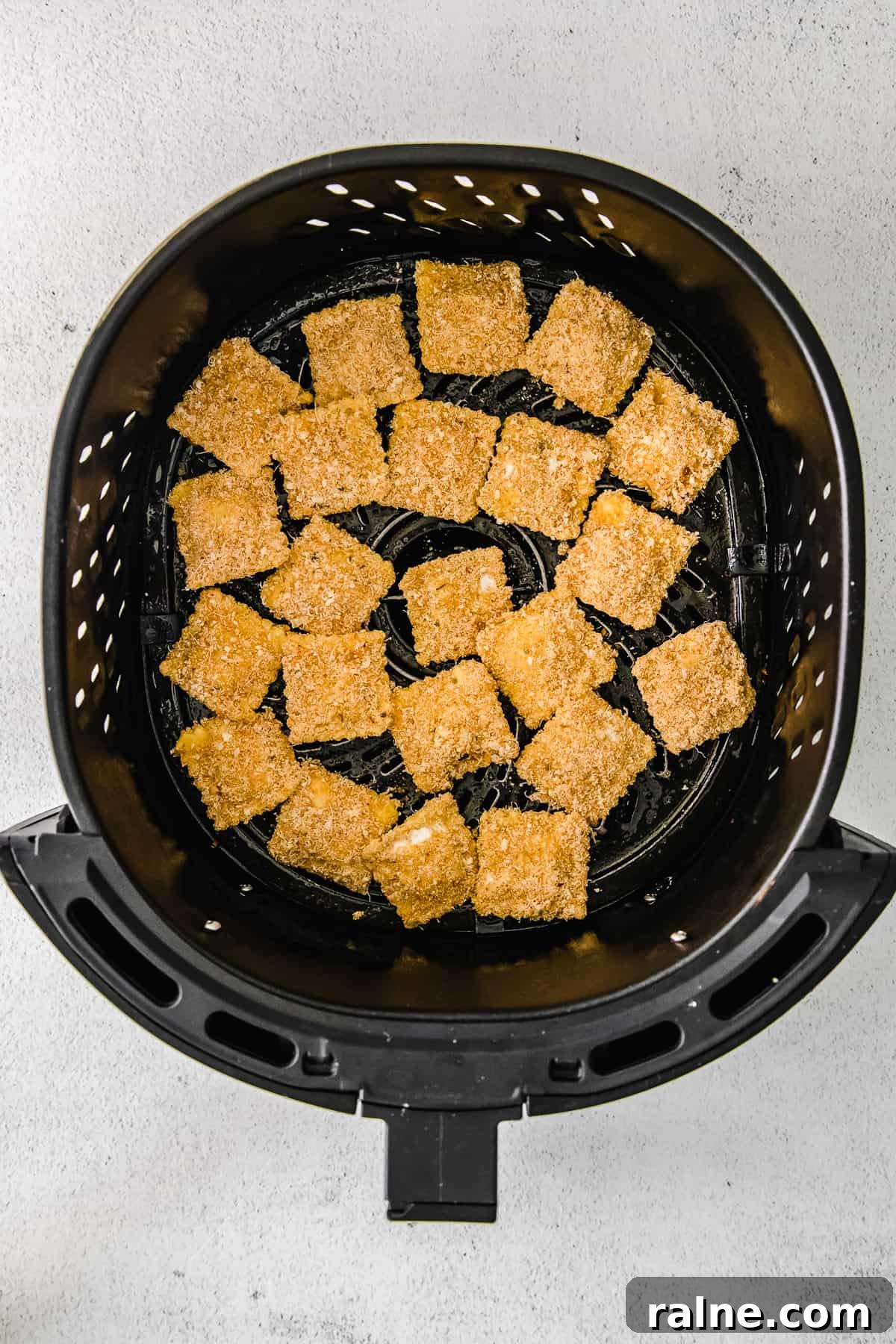 Crispy Air Fryer Ravioli Recipe — Quick Golden Bites 5 Coated ravioli in an air fryer.