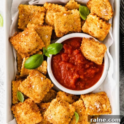 Crispy Air Fryer Ravioli Recipe — Quick Golden Bites 7 Air Fryer Ravioli served next to marinara sauce.