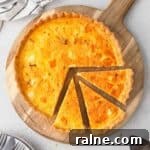Flatlay of the pumpkin quiche on a wooden board with 3 slices cut off.
