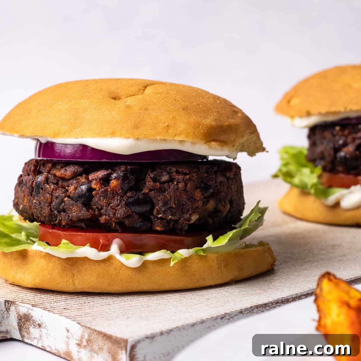 Juicy Mushroom Burger Recipe with Savory Grill-Style Flavor 2 mushroom burgers in a bun with potato wedges on the side.