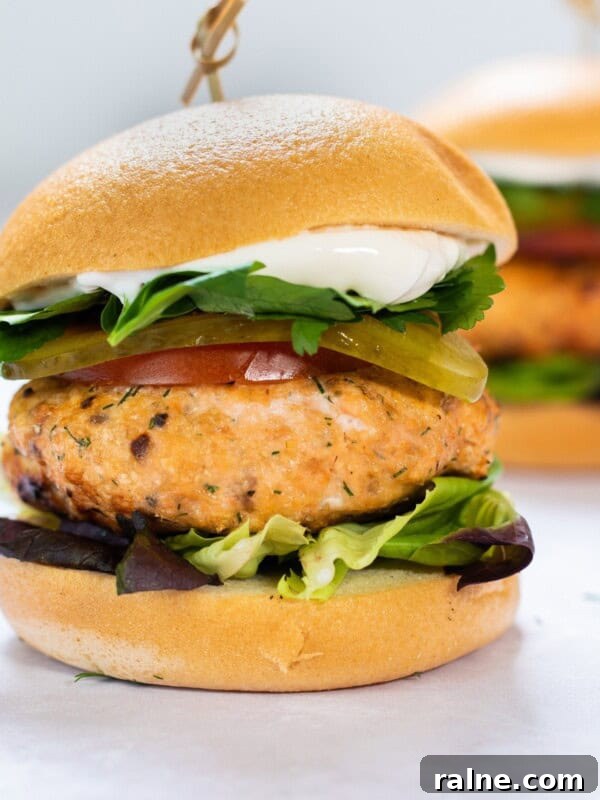 Juicy Mushroom Burger Recipe with Savory Grill-Style Flavor 11 salmon burger with bun and lettuce on white background.