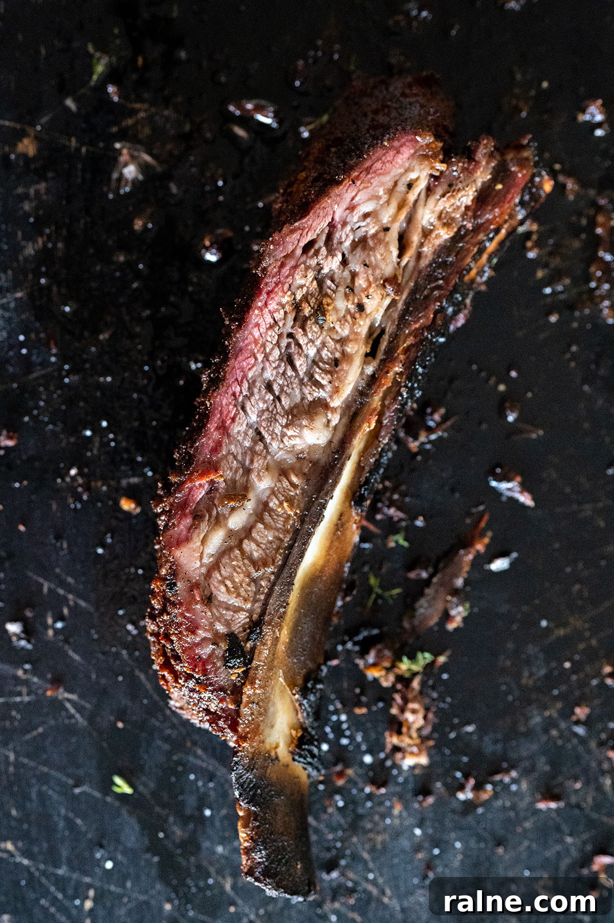 Beef Ribs Guide: Short Ribs, Back Ribs, Flanken & Cooking Tips 7 one smoked dino rib on a black board.