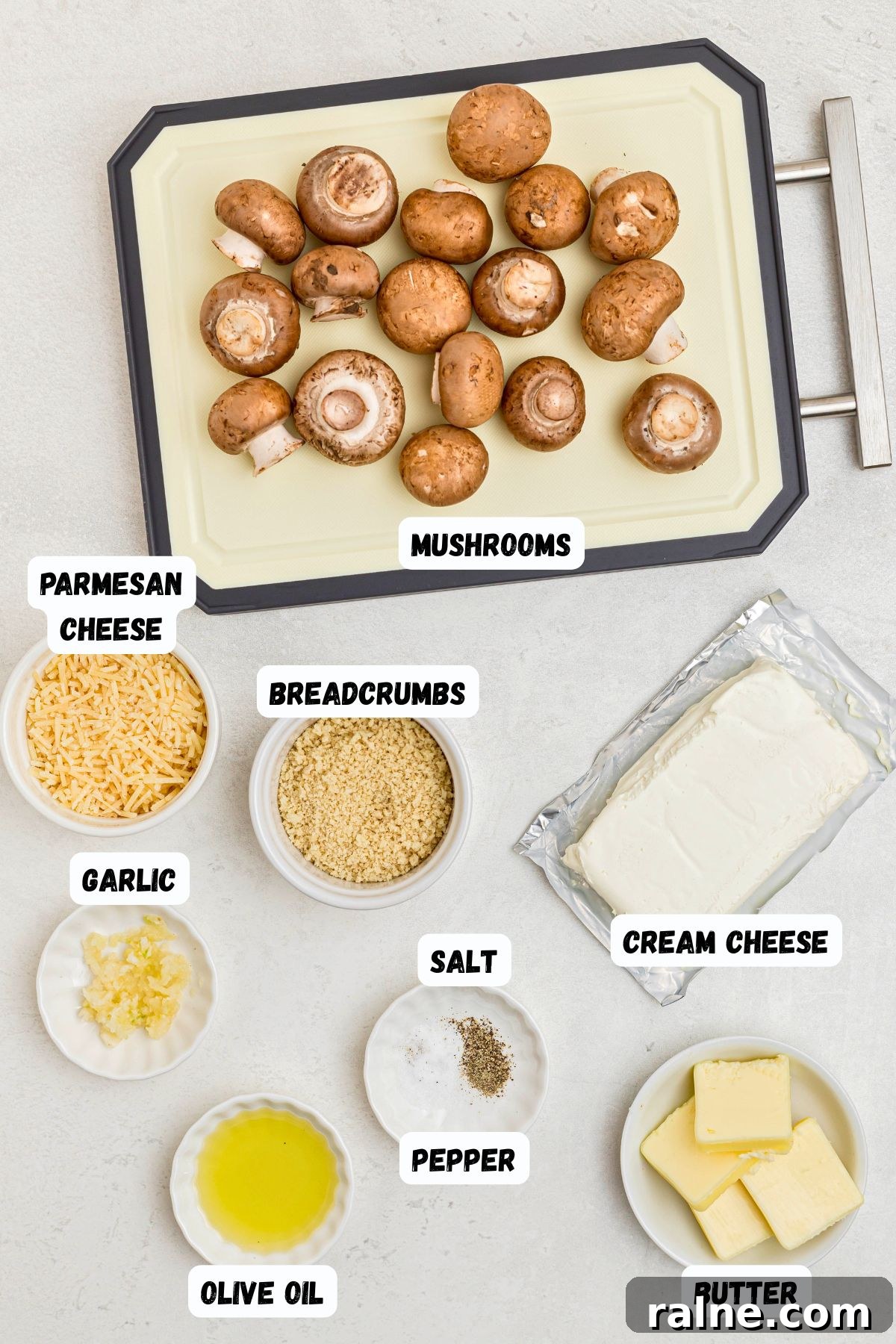 Cheesy Garlic Stuffed Mushrooms with Herb Breadcrumbs 3 Ingredients measured out in small dishes, and labeled, on a white marble table.