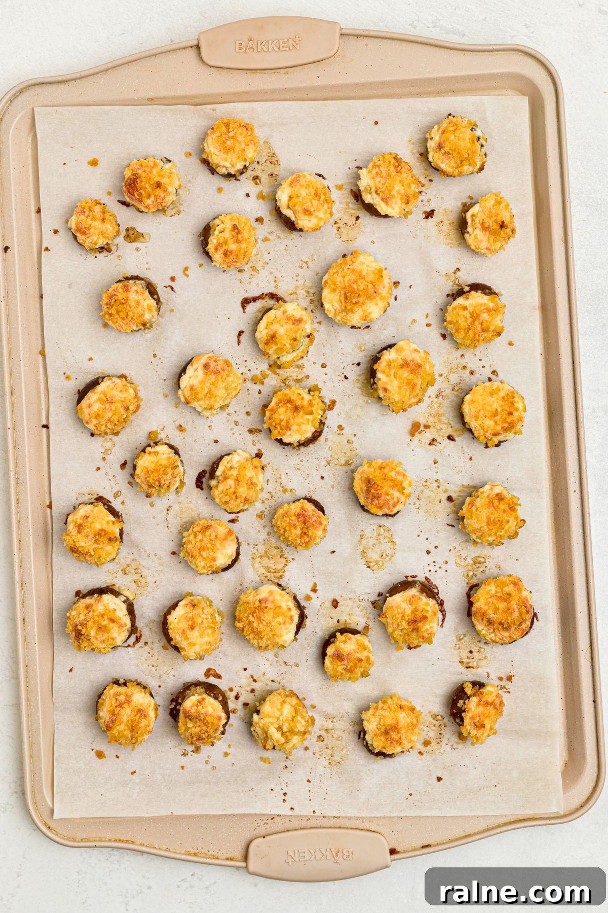 Cheesy Garlic Stuffed Mushrooms with Herb Breadcrumbs 9 Stuffed mushrooms on a baking sheet, lined with parchment paper, after baking.