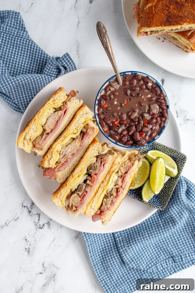 How to Make an Authentic Cuban Sandwich at Home 3 Overhead view of cut open cuban sandwiches revealing the ingredients on the inside.