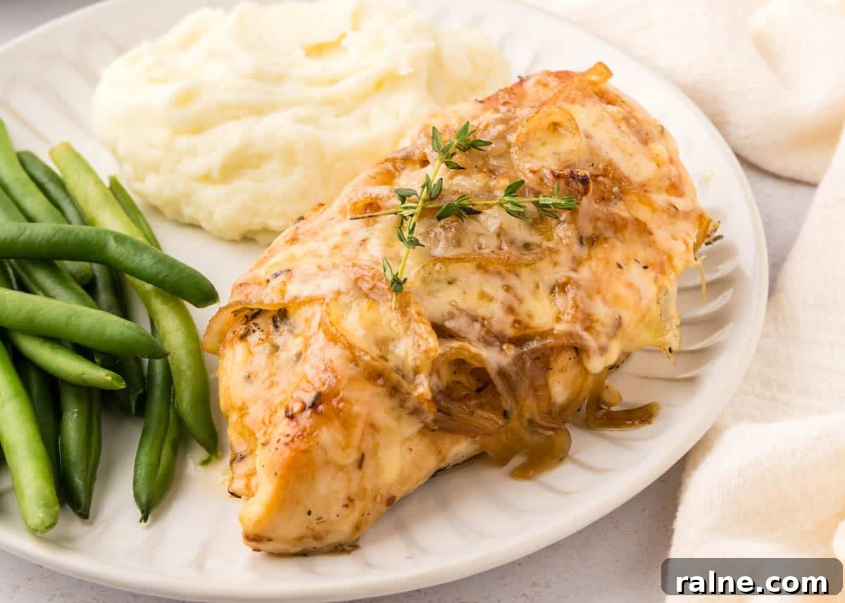 Quick Chicken Dinners for Busy Weeknights 2 A plate with french onion chicken topped with onions and herbs, served with mashed potatoes and green beans.