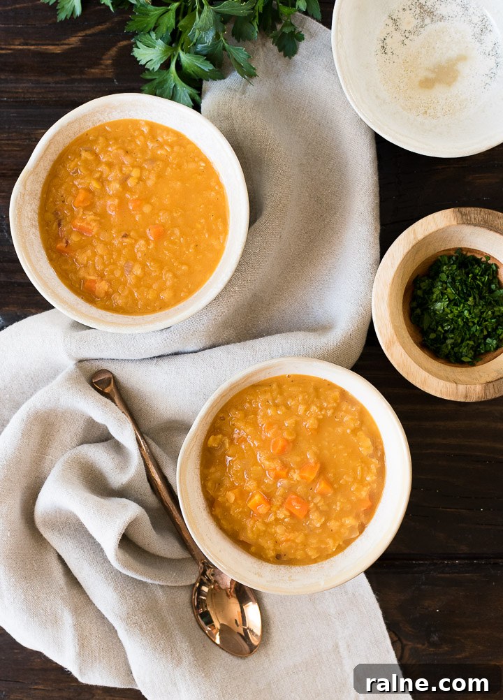 Creamy Coconut Red Lentil Soup with Warm Spices 4 two bowls of red lentil soup on a taupe linen on a dark wood table