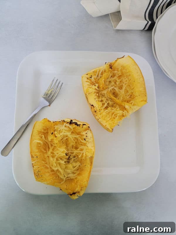 Crispy Air Fryer Spaghetti Squash with Garlic Parmesan 7 Air fryer spaghetti squash on a white plate with a fork
