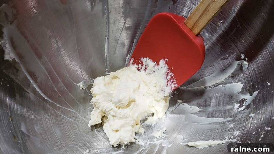 cream cheese, powdered sugar and vanilla mixed together in a bowl.