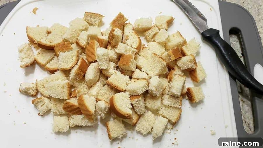 bread cut into cubes on a cutting board.