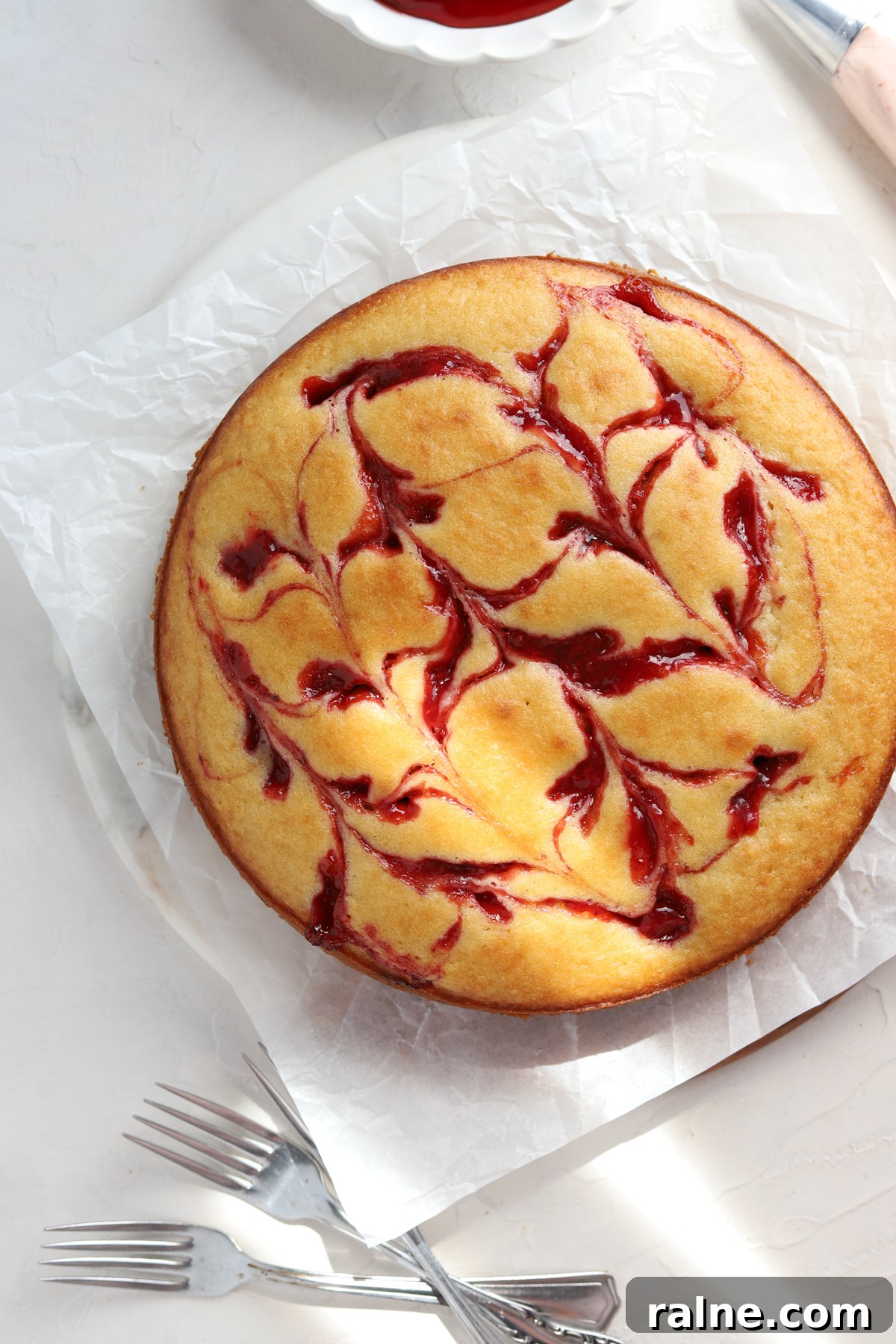 Pie-Inspired Birthday Cake Ideas for a Memorable Celebration 3 A golden brown cake with pie filling swirled in on parchment paper.