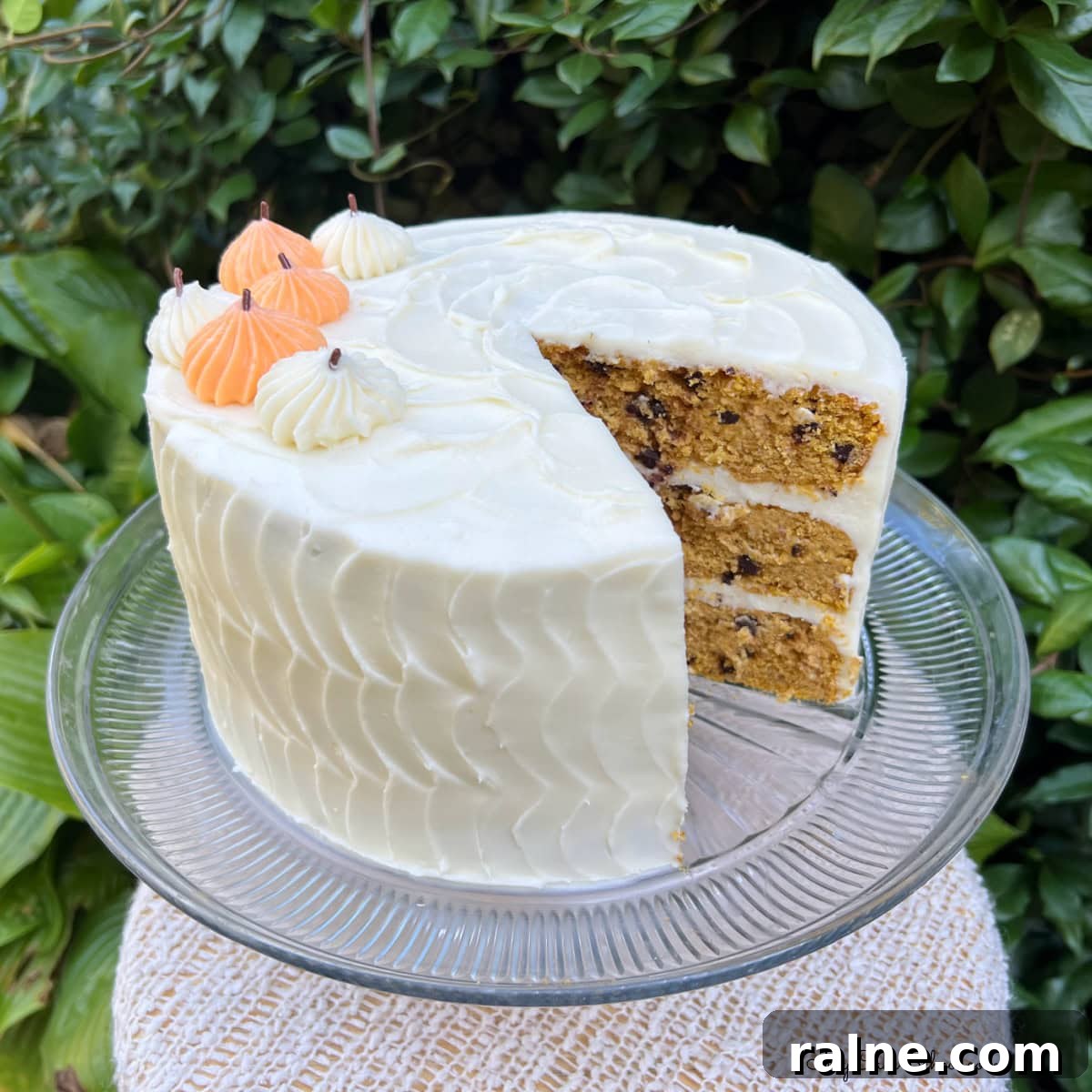 Pumpkin Chocolate Chip Cake, sliced, on a cake pedestal.