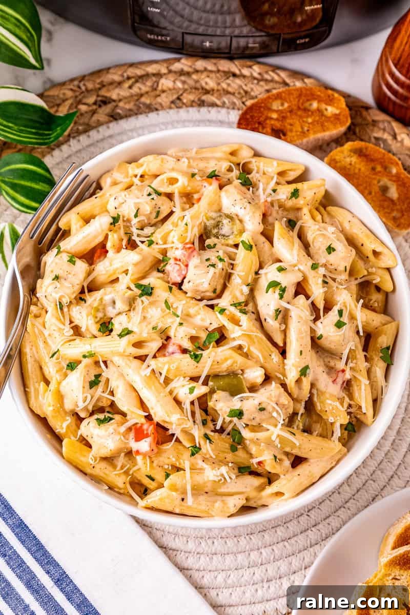 Slow Cooker Cajun Chicken Pasta Recipe for Flavorful Meals 5 a plate of crock pot Cajun pasta with chicken topped with Parmesan cheese and parsley.