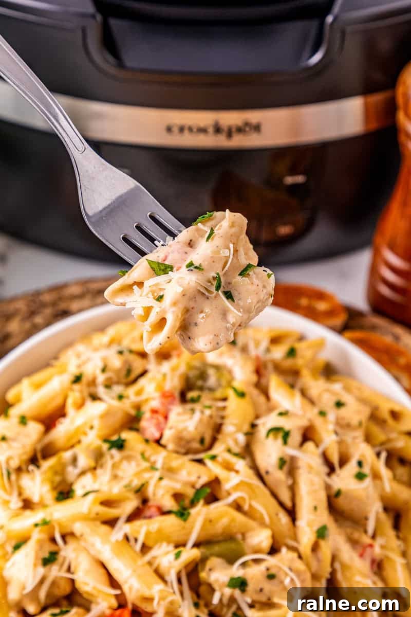 Slow Cooker Cajun Chicken Pasta Recipe for Flavorful Meals 7 a forkful of Cajun pasta with chicken.