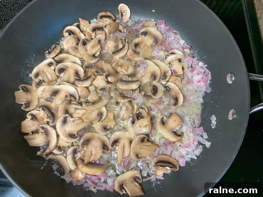 Mushrooms, red onions and garlic sautéing in a skillet