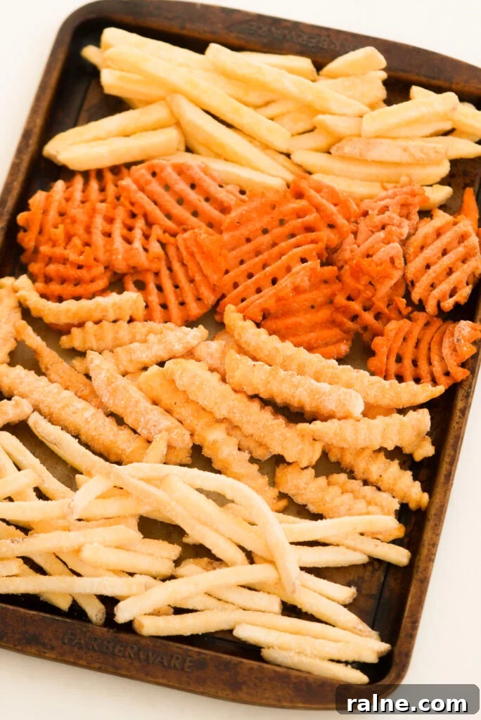 Baking sheet with frozen fries (sweet potato waffle, classic cut, crinkle cut, fast food style)