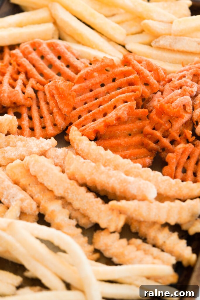 Frozen fries of multiple varieties on a baking sheet