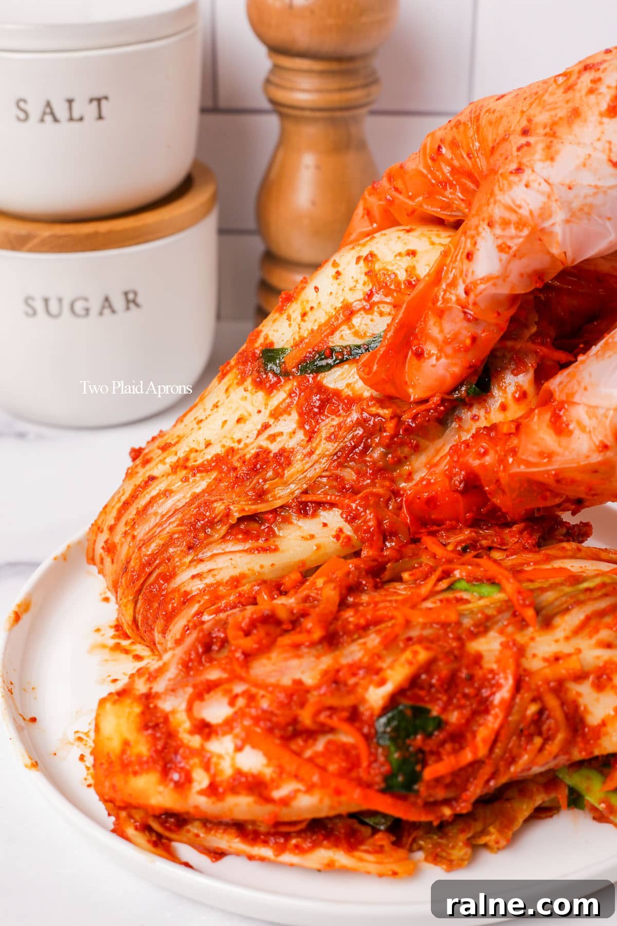 Napa Cabbage Kimchi Recipe: Authentic Homemade Kimchi Guide 3 Placing down kimchi on plate.