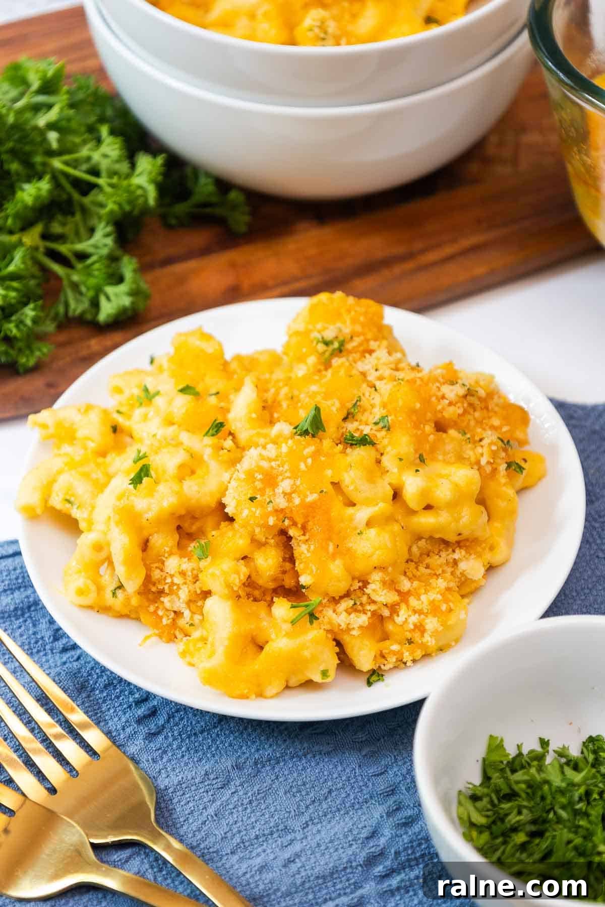 Old-Fashioned Baked Mac and Cheese with Ritz Cracker Topping 11 Close-up of a plate filled with old fashioned baked mac and cheese with Ritz cracker topping, garnished with fresh parsley.