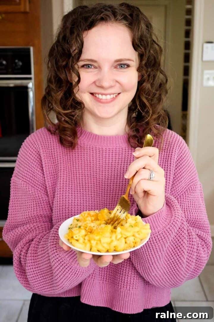 Old-Fashioned Baked Mac and Cheese with Ritz Cracker Topping 12 Kelsey Smith holding a plate of macaroni and cheese.