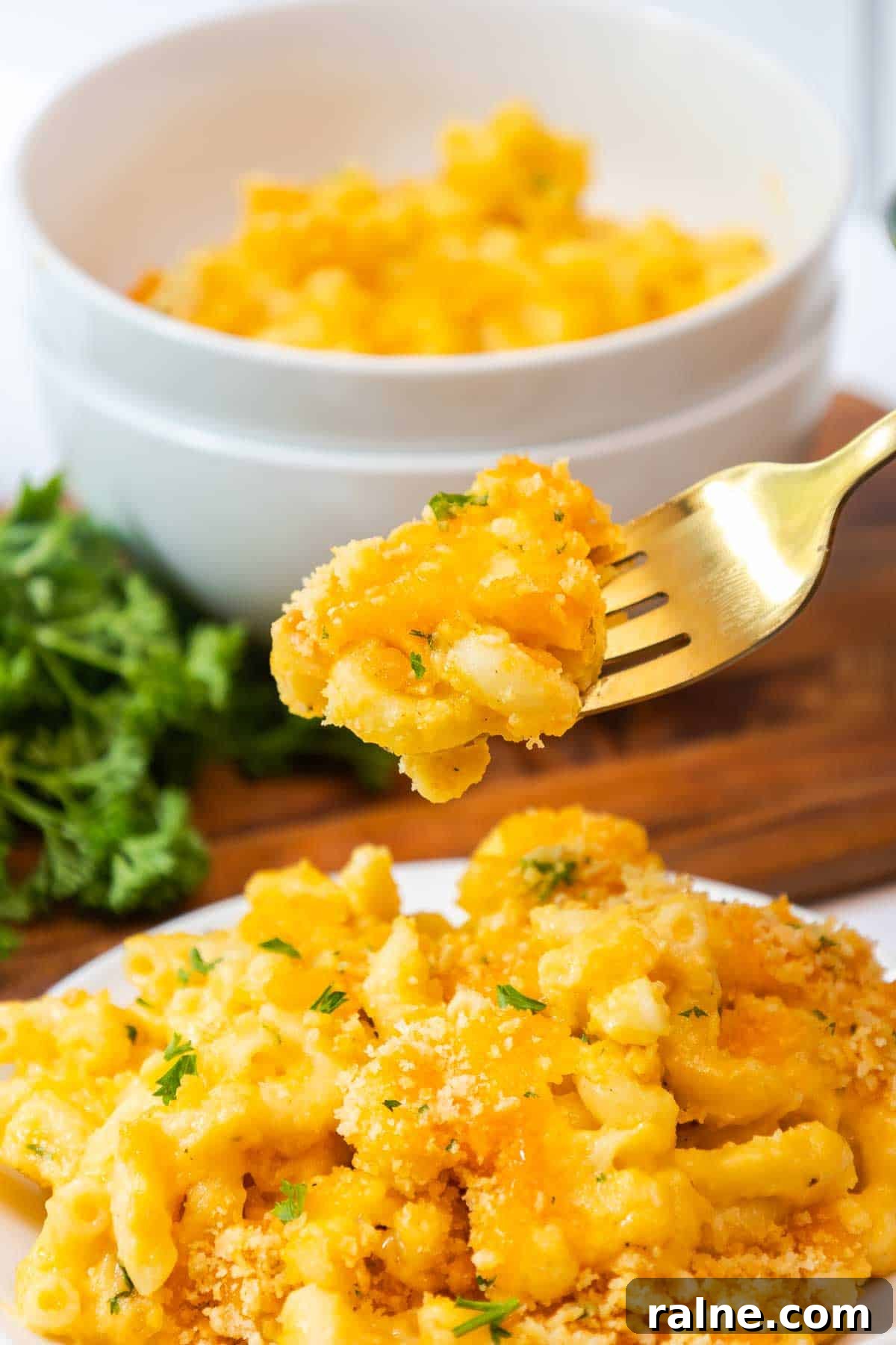 Old-Fashioned Baked Mac and Cheese with Ritz Cracker Topping 13 A fork lifting a cheesy bite of old fashioned baked mac and cheese.