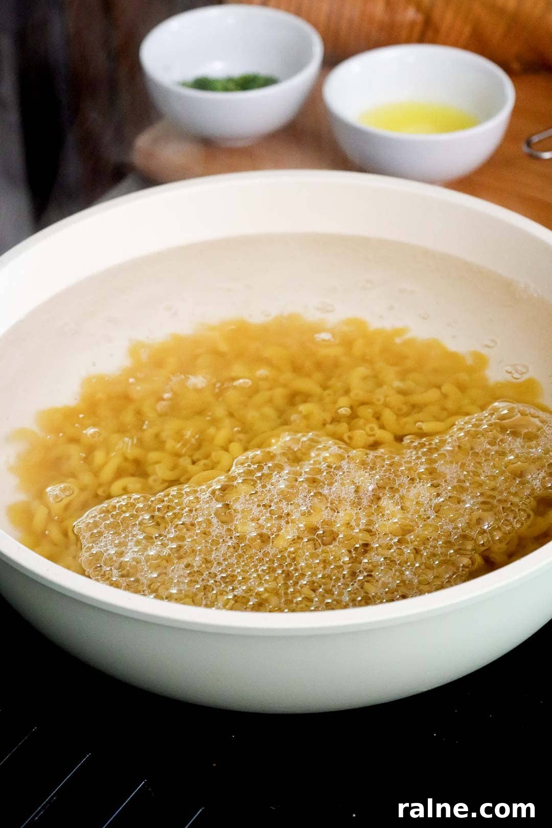 Old-Fashioned Baked Mac and Cheese with Ritz Cracker Topping 4 Elbow macaroni boiling in a large white pot of bubbling water.